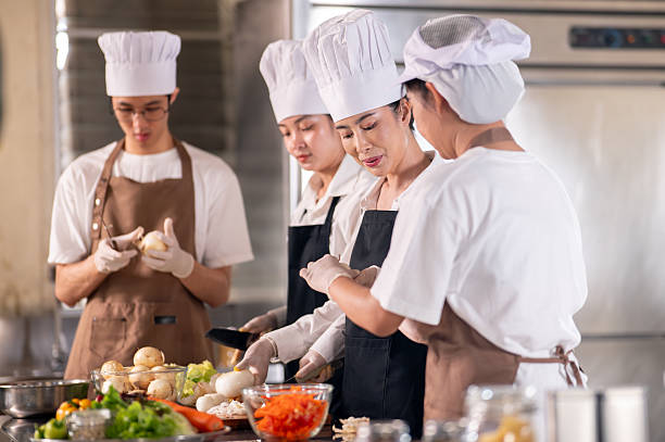istock Asian female chef is looking at her students or assistant peeling onions at kitchen cooking counter. 2230071088