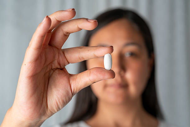 istock Woman hand holding a white pills 2230071833