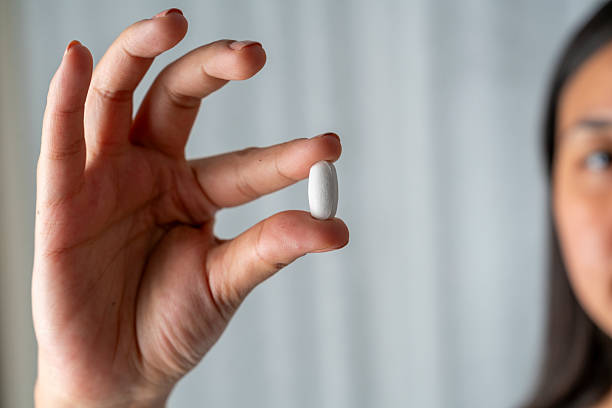 istock Woman hand holding a white pills 2230071835