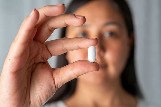 istock Woman hand holding a white pills 2230071838