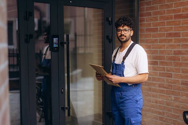 istock Delivery man holding package and checking address on clipboard 2230075019