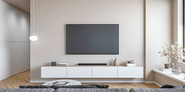 istock A modern minimalistic living room with a LCD screen on empty beige wall with copy space, a low white cabinet, coffee table, gray sofa, windows and decoration, a hallway 2230075980