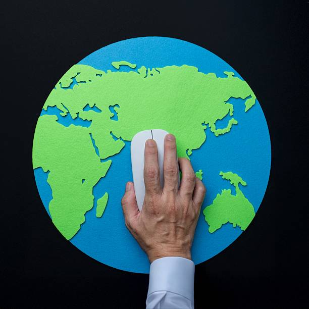 istock An overhead shot of a hand operating a computer mouse on a map of the Earth. 2230076231