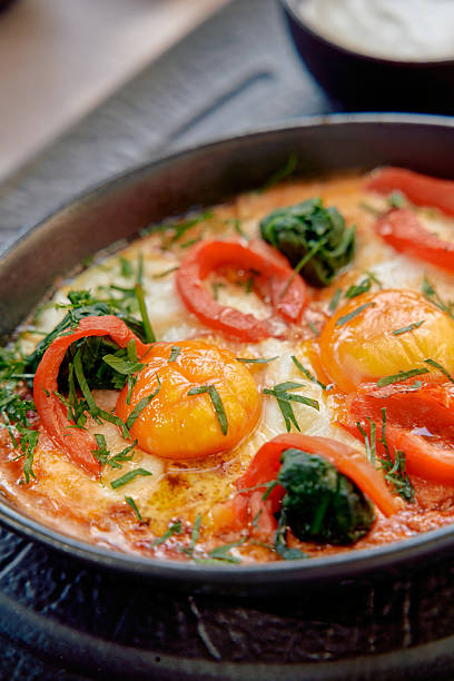 istock Deliciously Baked Eggs with Fresh Vegetables Including Spinach, Bell Peppers, and Herbs Served in a Rustic Pan for a Perfect Breakfast 2230078183