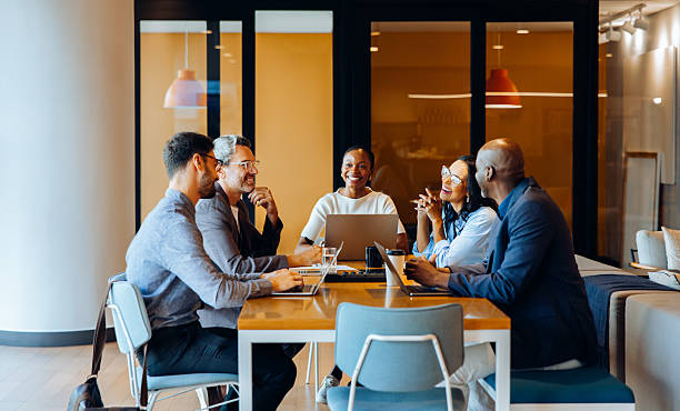 istock Group discussing strategies in an office with laptops and cheerful interaction 2230079779