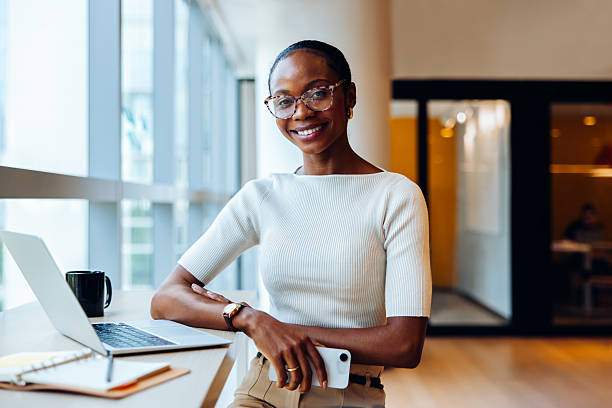 istock Confident young professional woman with a laptop and notepad in office 2230079861