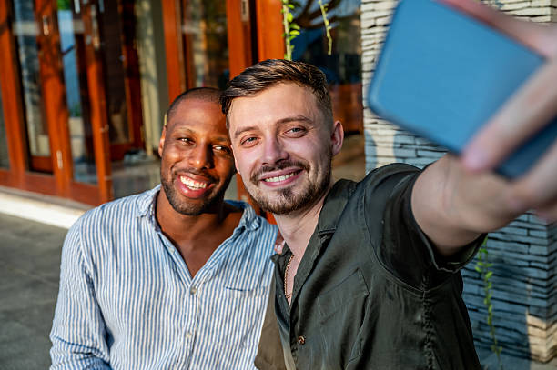 istock Two Friends Taking a Cheerful Selfie Outdoors During a Bright Day 2230083598