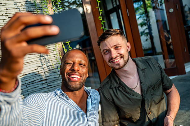 istock Smiling Friends Taking a Casual Selfie Outdoors on a Sunny Day 2230083606
