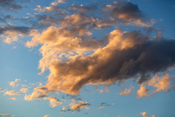 A large textured yellow cloud against a blue sky captured in the afternoon light.
