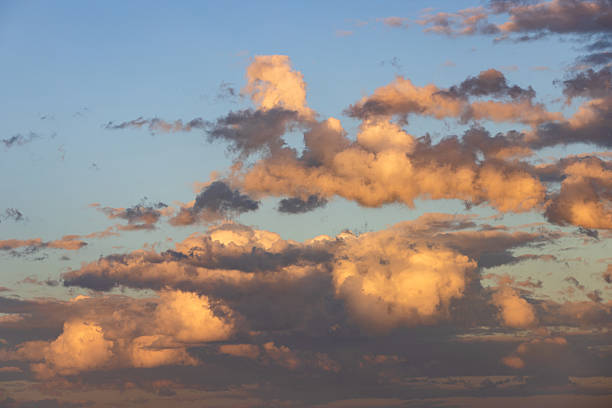 istock Textured yellow clouds floating in a blue sky captured in the afternoon light. 2230086193