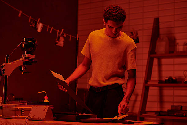 istock Crafting memories in red light while developing film in a cozy urban darkroom setting 2230087054