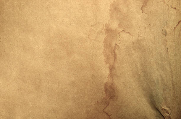 Old yellow aged paper vintage and texture background. Abstract grunge brown beige grunge pattern. The surface and edges material are torn and weathered with coffee and tea and water stains. Dirty paper texture. Blank sheet copy space abstract pattern effect surface level suit for wall paper screen saver, design. Dark, dirty, dust and scratches texture.