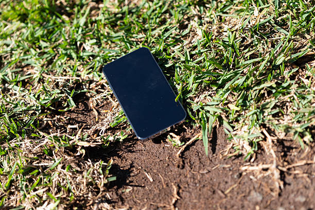 Mobile phone dropped on mud and grass