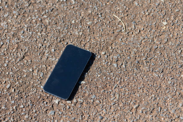 Lost mobile phone on an asphalt road