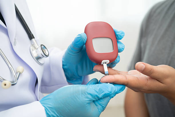 istock Asian doctor using digital glucose meter for check sample blood sugar level to treatment diabetes. 2230090991