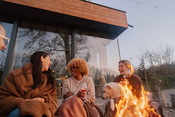 istock Female friends relaxing by the campfire and drinking wine 2230093844