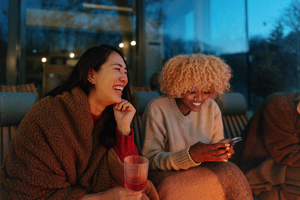 istock Female friends relaxing by the campfire and drinking wine 2230093866