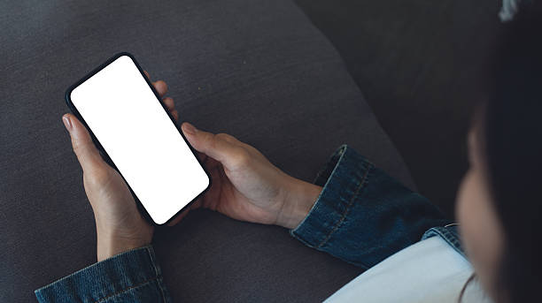 istock Mockup, blank screen cell phone. Woman hand holding, using mobile phone at home with white empty space for advertise text. contact business, social meida communication, technology device, closeup 2230098127