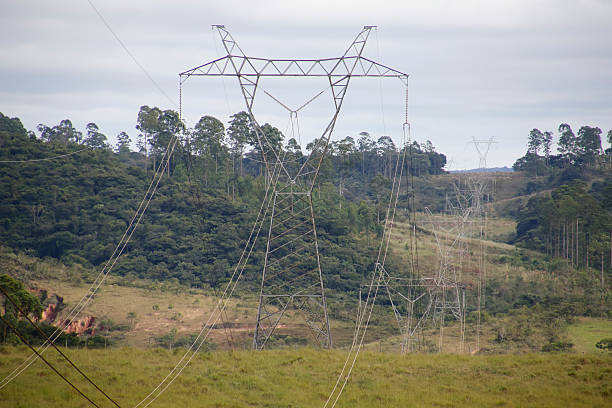 istock Electric power transmission towers aligned under open sky 2230102587