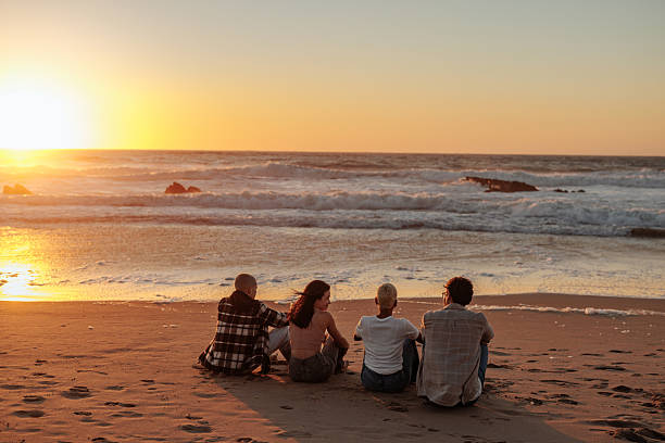 istock Friends enjoying golden sunset on sandy beach 2230103097