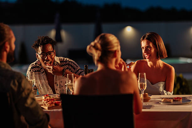 istock Friends Enjoying Dinner Outdoors at Night 2230103163