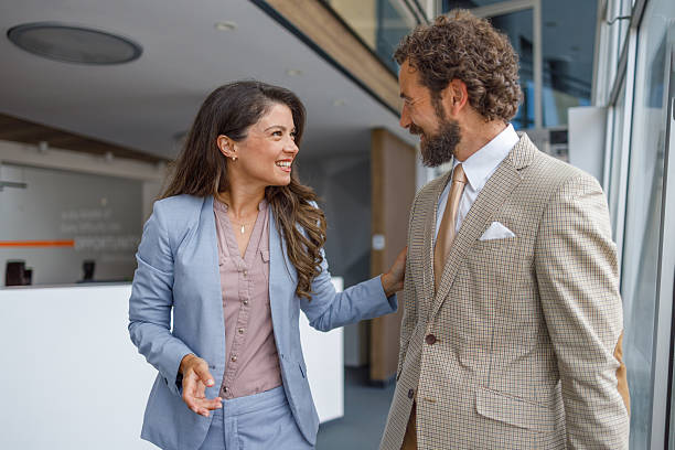 istock Business people smiling and walking through office building lobby 2230103436