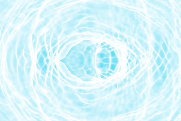 Blue water with ripples on the surface. Defocus blurred transparent blue colored clear calm water surface texture with splashes and bubbles. Water waves with shining pattern texture background.