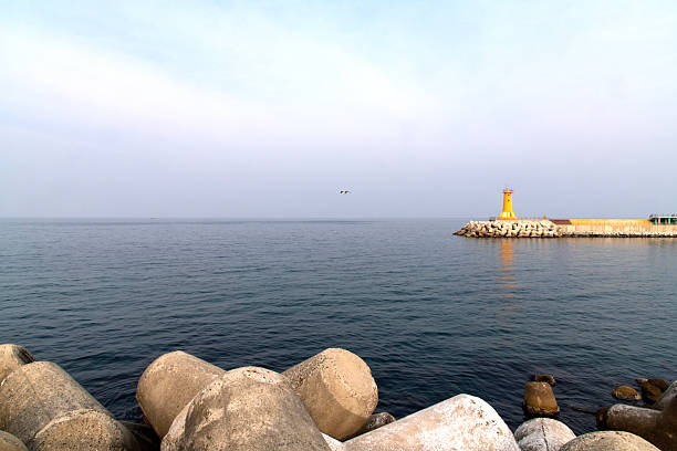 tetrapods and jetty with lighthouse on the sea