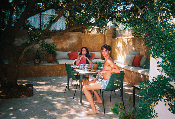 Photo taken with a disposable camera. Friends relaxing at an outdoor Mediterranean patio table.
