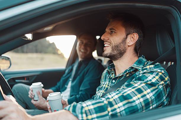 istock Two friends talking and drinking coffee in car 2230105345