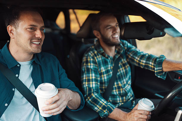istock Two friends talking and drinking coffee in car 2230105370