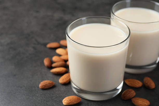 istock Fresh almond milk in glasses and nuts on dark grey table, closeup 2230115255