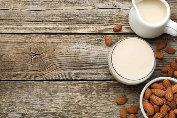 istock Fresh almond milk and nuts on wooden table, top view. Space for text 2230115315