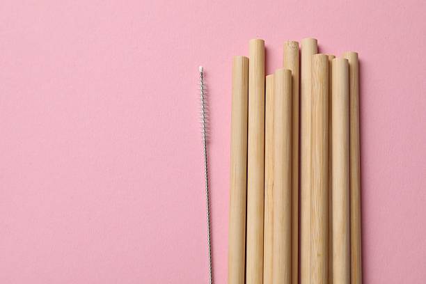 istock Bamboo drinking straws and cleaning brush on pink background, top view. Space for text 2230115749