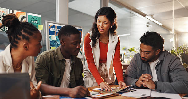 istock Creative, layout and woman with team in meeting for planning, collaboration and project ideas. Startup agency, office and workers with documents brainstorming for design process, feedback or strategy 2230117291