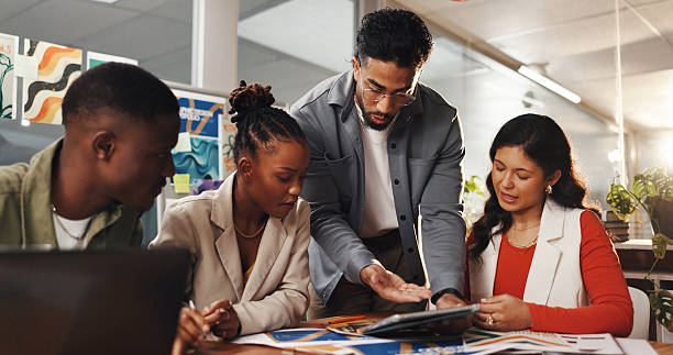 istock Creative, tablet and man with team in meeting for planning, brand layout and project ideas. Digital agency, collaboration and workers brainstorming on tech for design process, feedback and strategy 2230117293