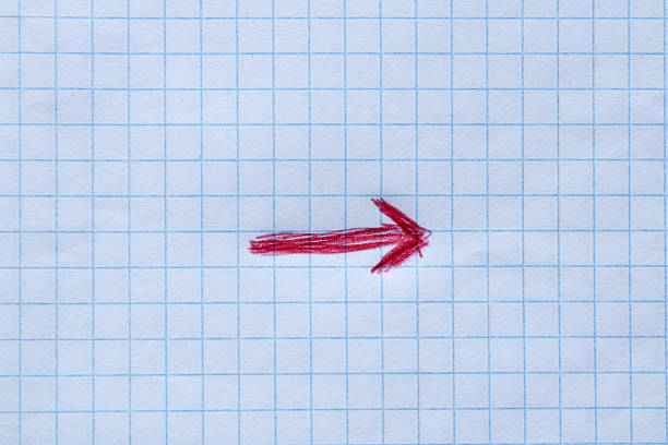 A red arrow drawn by hand on a sheet of squared notebook that points to the right, close-up