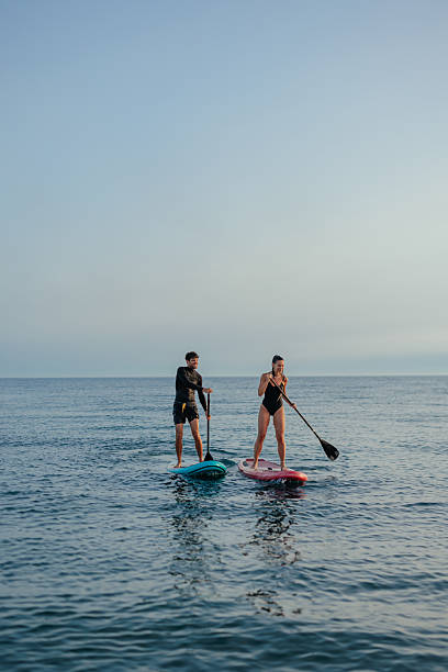 istock Two tourists paddleboarding on a vacation 2230118406