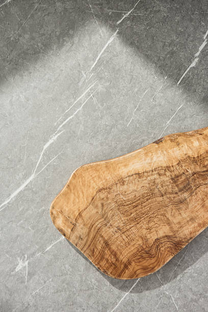 istock Wooden serving board on gray marble, bright natural lighting, minimal overhead composition 2230118502