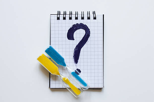 istock A notebook in a cage with a dark blue question mark drawn on it, next to it an hourglass with yellow and blue sand in the colors of the Ukrainian flag on a white 2230118714