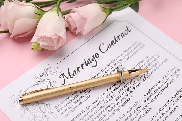 istock Marriage contract, flowers, pen and ring on pink background, closeup 2230120121
