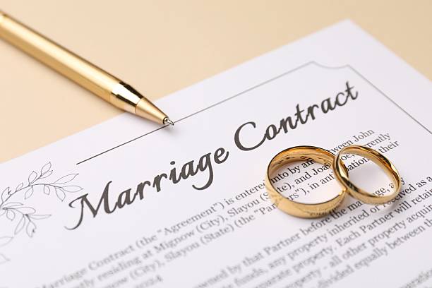 istock Marriage contract, pen and golden rings on beige background, closeup 2230120122