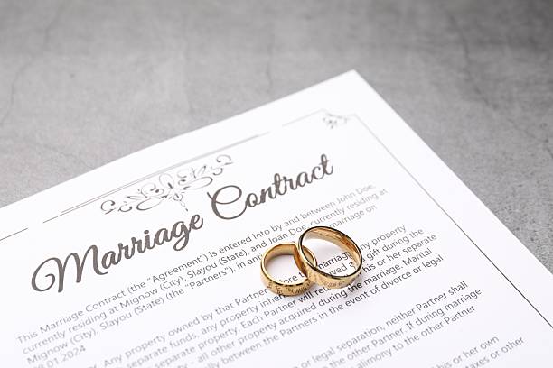 istock Marriage contract and golden rings on grey table, closeup 2230120145