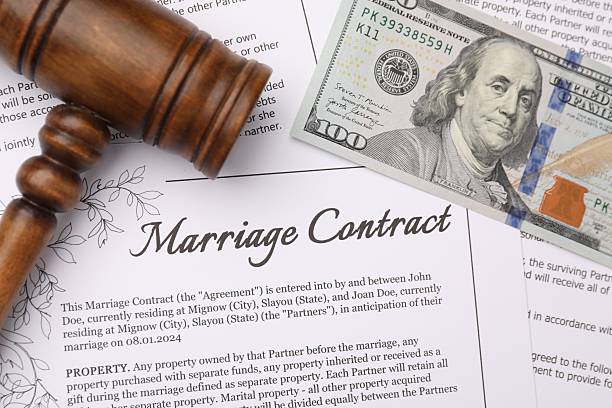 Marriage contract, gavel and dollar bill, top view