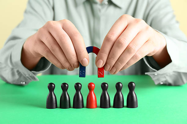 istock Woman with magnet attracting game pieces at green table, closeup 2230120732