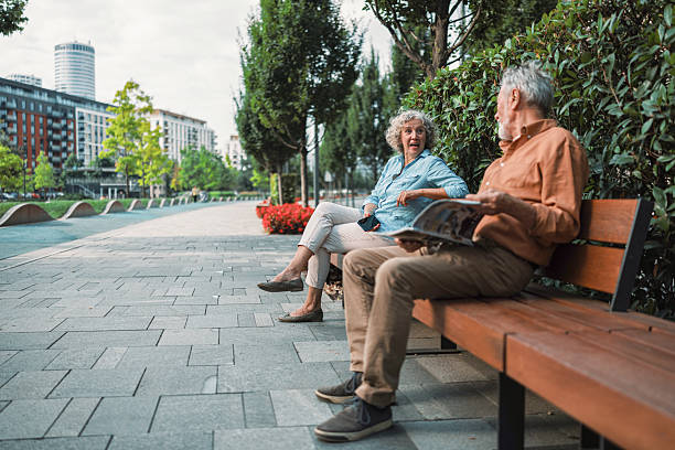 istock Strangers sitting together on a park bench 2230121676