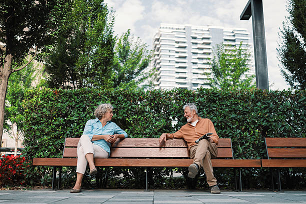 istock Strangers starting conversation on park bench 2230121716