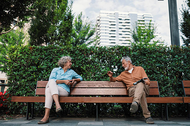istock Casual talk between strangers on public bench 2230121736