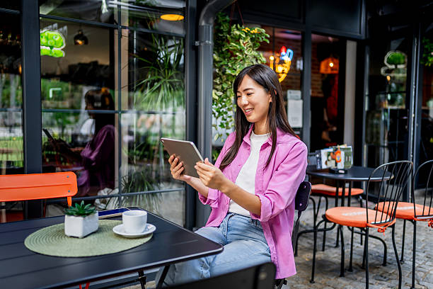 istock Young asian woman using digital tablet at outdoor cafe 2230121744