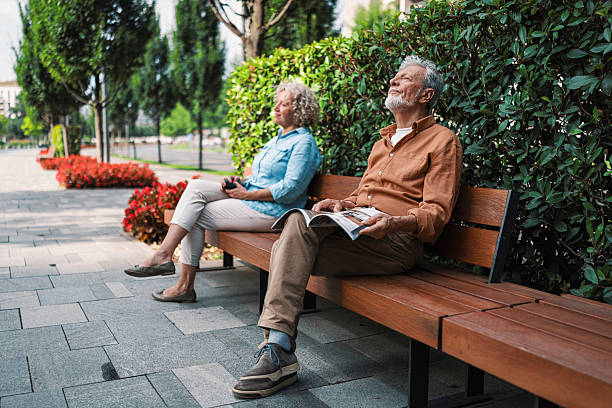 istock People relaxing on park bench enjoying sunny day 2230121746